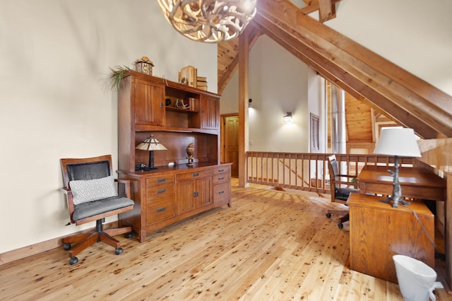 sitting room featuring high vaulted ceiling, an upstairs landing, light wood-type flooring, beamed ceiling, and an inviting chandelier