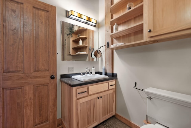 bathroom featuring vanity, toilet, and baseboards