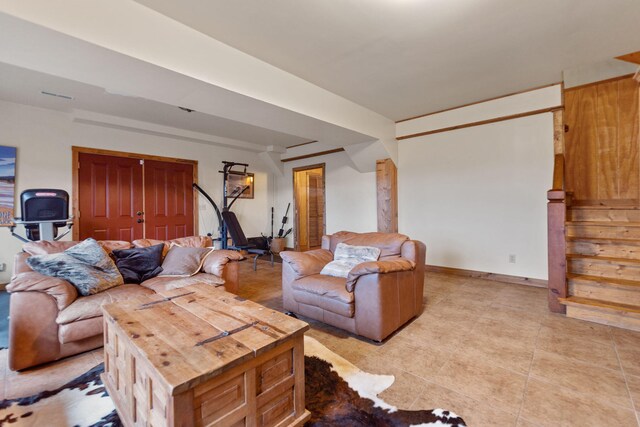 living room featuring stairway, light tile patterned flooring, and baseboards