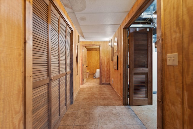 hallway featuring wood walls