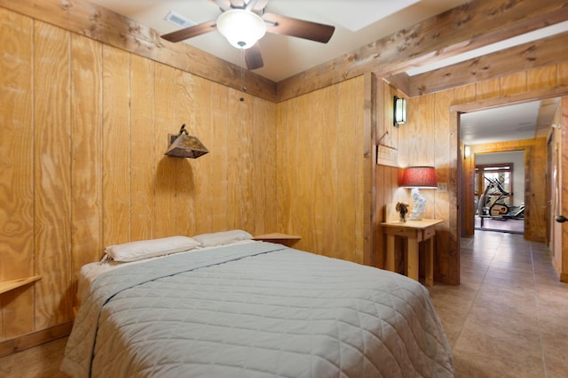 bedroom with a ceiling fan and wooden walls