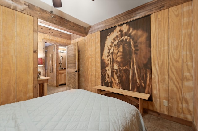 bedroom featuring wooden walls, beam ceiling, and ensuite bathroom