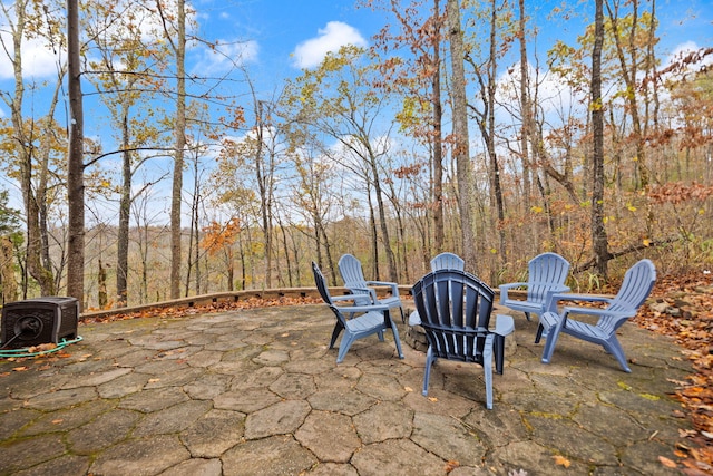 view of patio with central AC unit and a wooded view