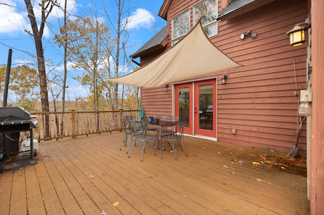 wooden terrace with outdoor dining space and grilling area