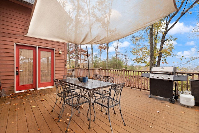 wooden deck with a grill and outdoor dining space