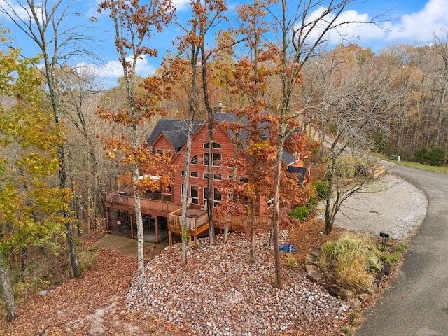 exterior space with a forest view and a deck