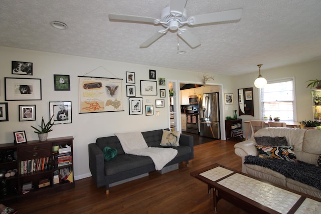 living room featuring a textured ceiling, ceiling fan, and dark wood-type flooring