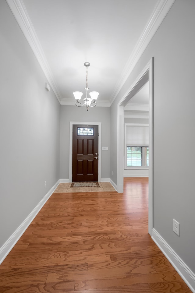 entrance foyer featuring a chandelier, hardwood / wood-style flooring, and ornamental molding