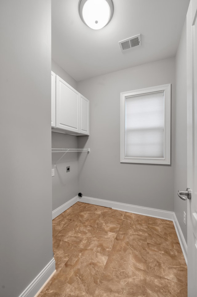 laundry room featuring electric dryer hookup and cabinets