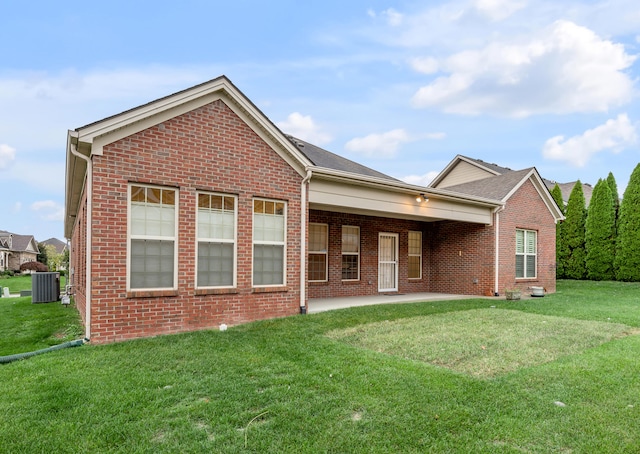 rear view of house with a lawn and central AC