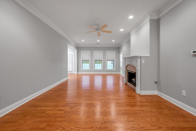 unfurnished living room featuring crown molding, ceiling fan, and light hardwood / wood-style floors