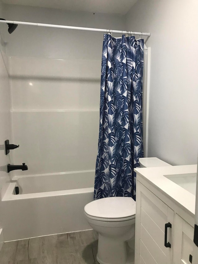 full bathroom with hardwood / wood-style floors, vanity, toilet, and shower / bathtub combination with curtain