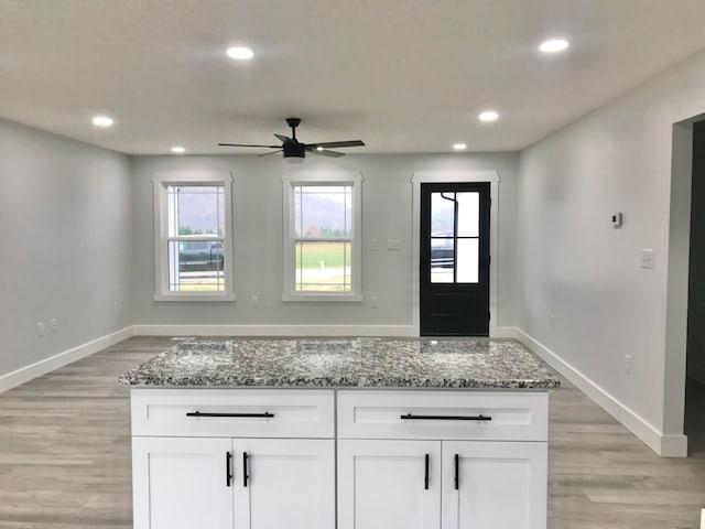 interior space featuring dark stone countertops, white cabinetry, and plenty of natural light