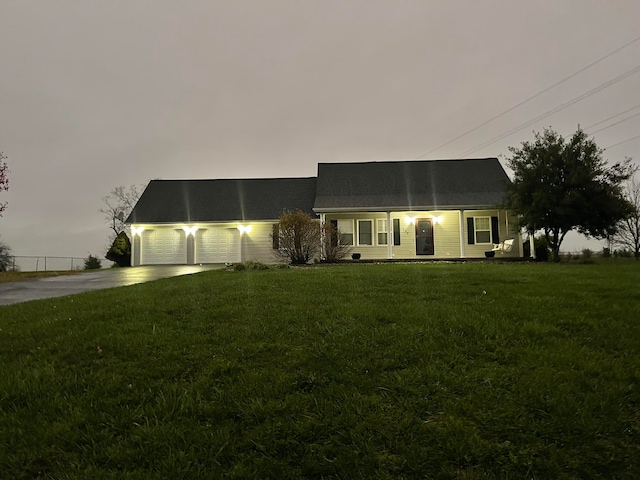 ranch-style house with a front lawn, covered porch, and a garage