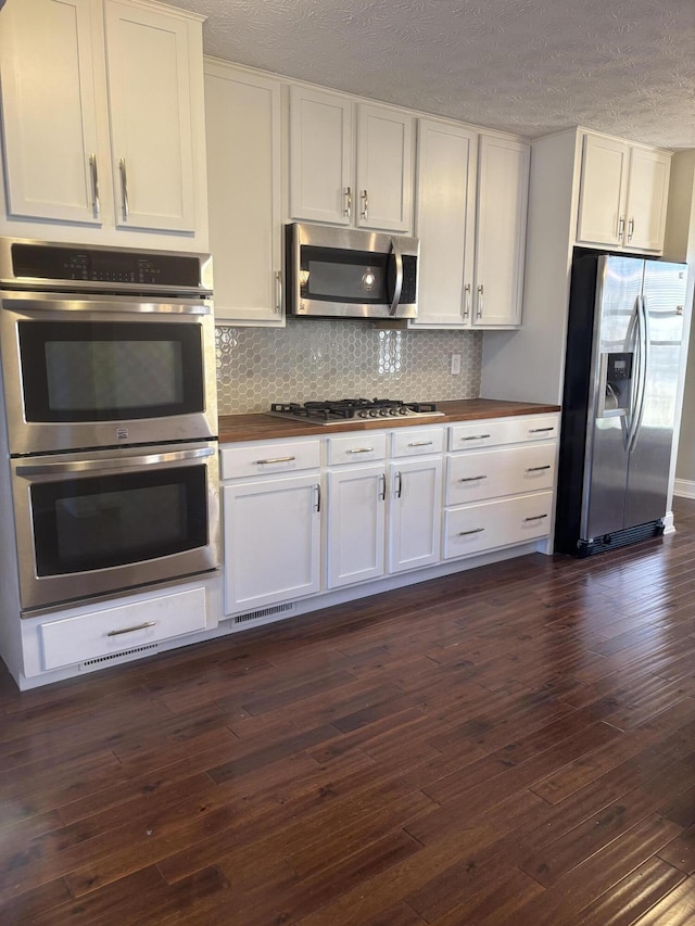 kitchen featuring appliances with stainless steel finishes, dark wood-style flooring, and white cabinetry