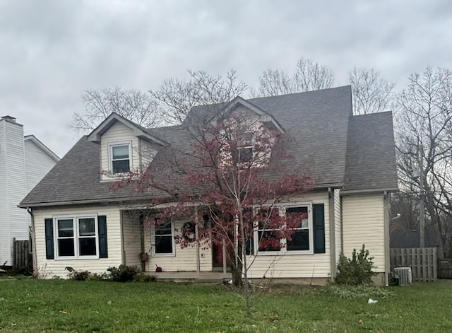 cape cod home with roof with shingles and a front lawn