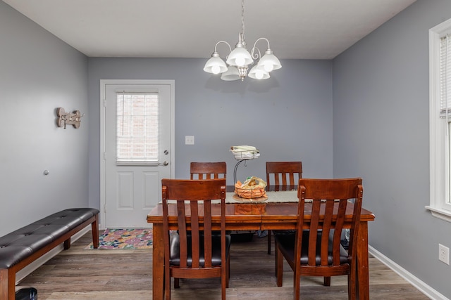 dining room with a chandelier, wood finished floors, and baseboards