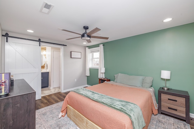 bedroom with a barn door, recessed lighting, baseboards, dark wood-style flooring, and a ceiling fan