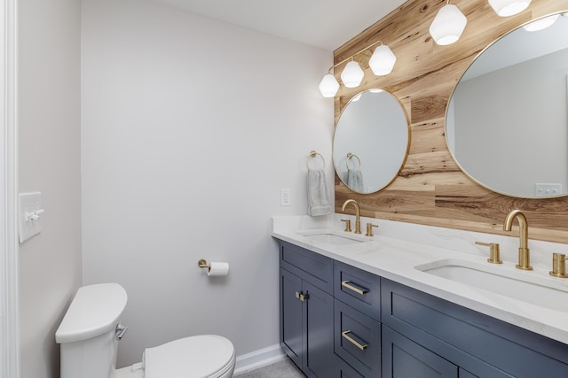 full bath with toilet, baseboards, and double vanity