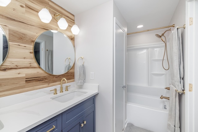 bathroom featuring washtub / shower combination, vanity, and recessed lighting