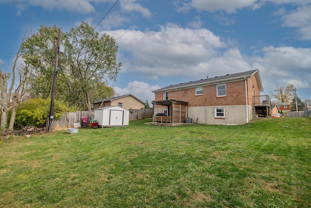 back of house featuring a storage unit, an outdoor structure, brick siding, and a deck