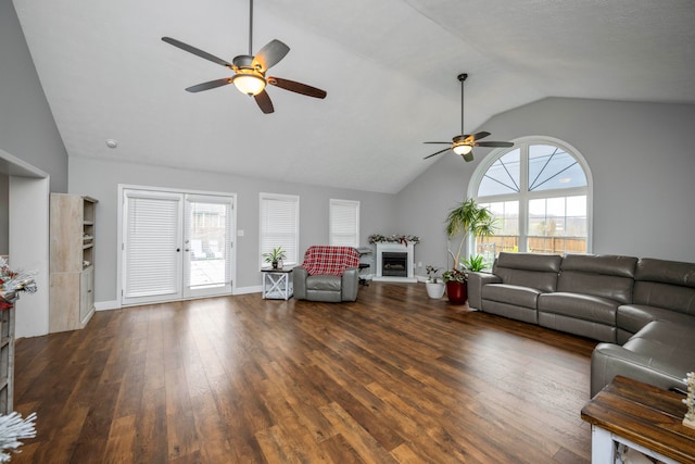 unfurnished living room with ceiling fan, dark wood-type flooring, and vaulted ceiling