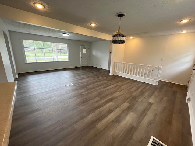 empty room featuring dark hardwood / wood-style flooring and a textured ceiling