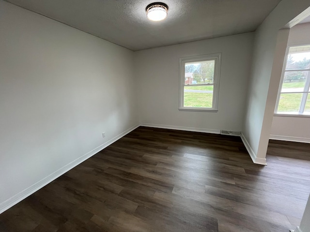 spare room with dark wood-type flooring and a textured ceiling