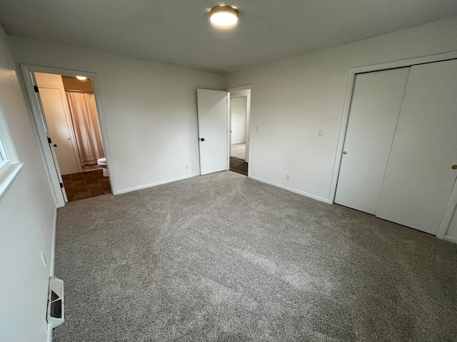 unfurnished bedroom with carpet flooring, connected bathroom, and a closet