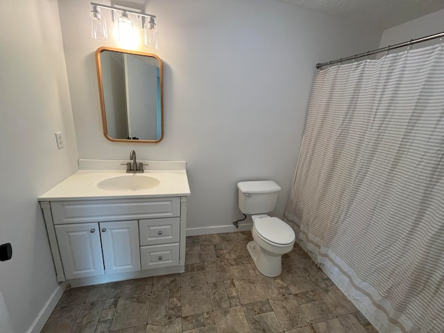 bathroom with walk in shower, vanity, a textured ceiling, and toilet