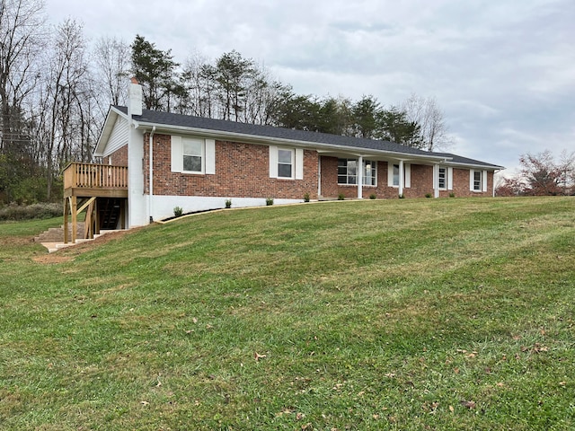 single story home with a front yard and a wooden deck