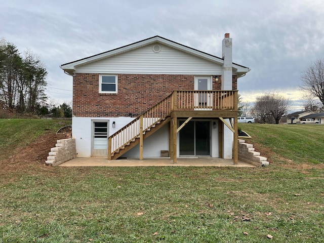 rear view of property with a lawn, a patio area, and a wooden deck