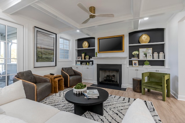 living room featuring built in shelves, light hardwood / wood-style floors, and beam ceiling