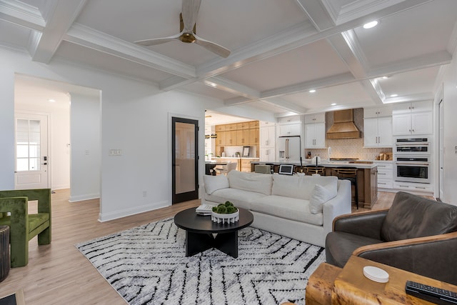 living room with ceiling fan, light hardwood / wood-style floors, ornamental molding, and beam ceiling