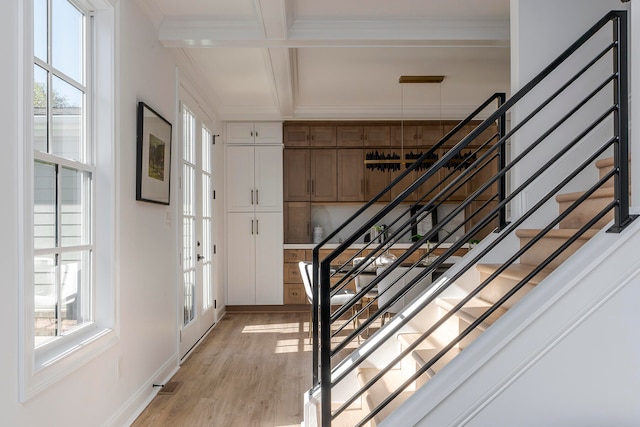 staircase featuring french doors, coffered ceiling, hardwood / wood-style flooring, ornamental molding, and beam ceiling