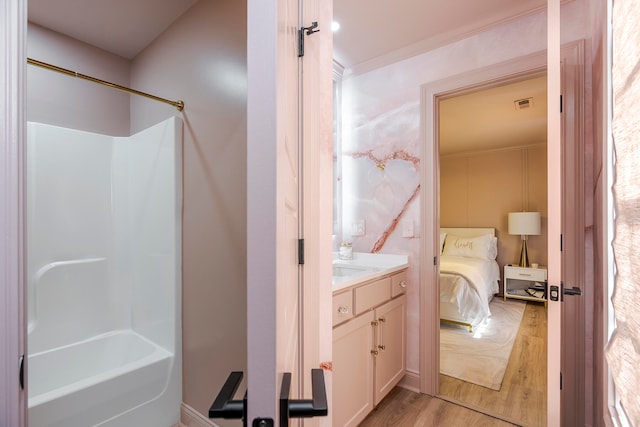 bathroom featuring hardwood / wood-style floors, vanity, shower / bath combination, and crown molding