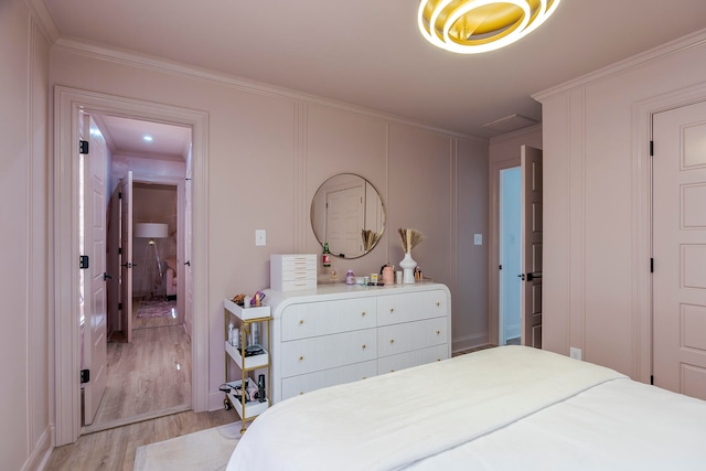 bedroom featuring crown molding and light hardwood / wood-style floors