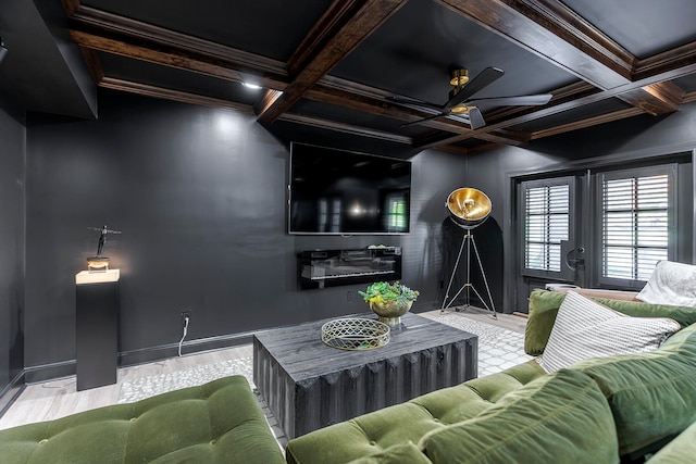 living room featuring beamed ceiling, ceiling fan, ornamental molding, and coffered ceiling