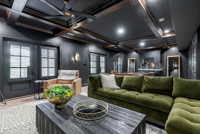 home theater room with beam ceiling, french doors, coffered ceiling, light hardwood / wood-style floors, and bar