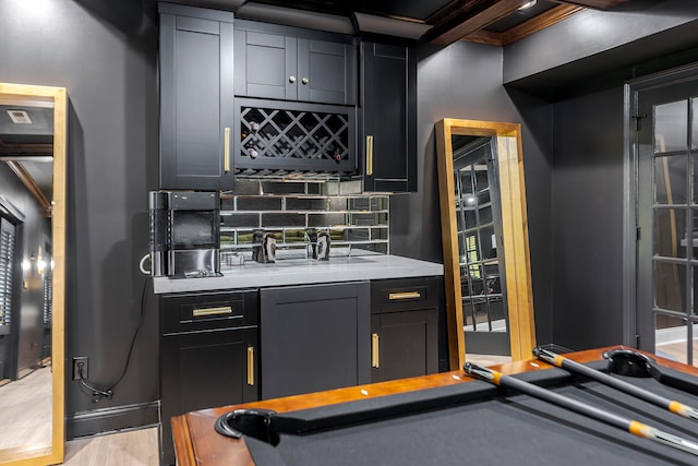 bar featuring tasteful backsplash, pool table, and light hardwood / wood-style flooring