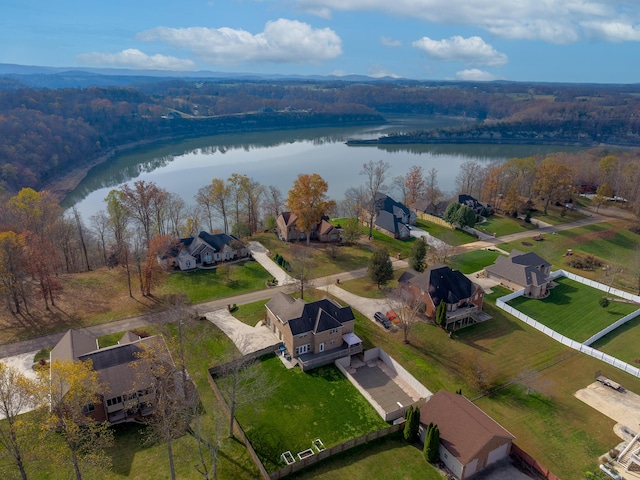 drone / aerial view with a residential view, a view of trees, and a water view