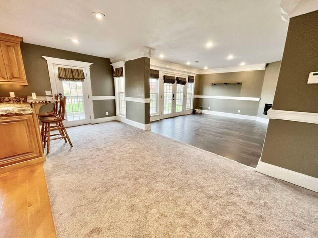 unfurnished living room featuring hardwood / wood-style flooring and ornamental molding