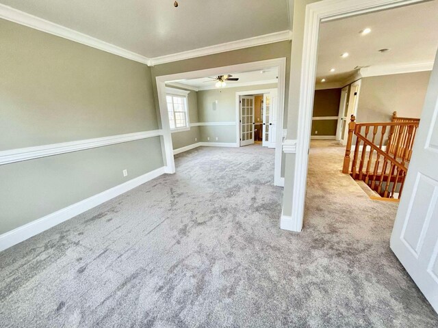 interior space featuring light colored carpet, ceiling fan, and ornamental molding