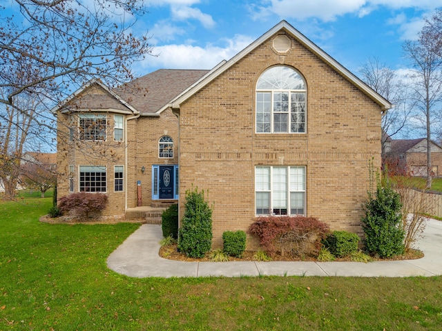 traditional-style house featuring a front lawn and brick siding