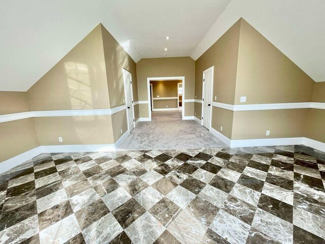 additional living space featuring ceiling fan and vaulted ceiling