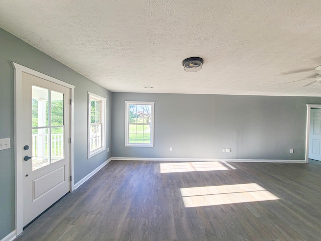 interior space featuring dark hardwood / wood-style floors, ceiling fan, and a textured ceiling