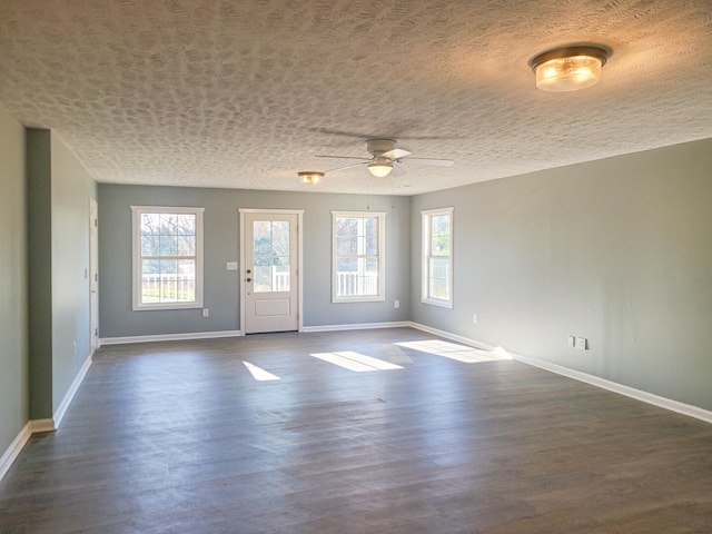 spare room with a textured ceiling, ceiling fan, and dark hardwood / wood-style floors