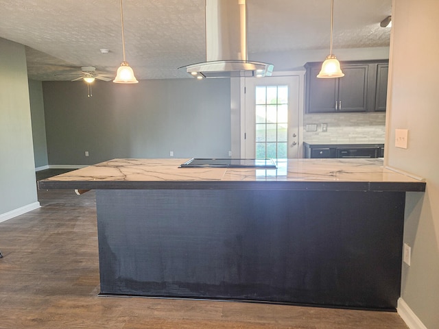 kitchen featuring kitchen peninsula, dark hardwood / wood-style floors, hanging light fixtures, and exhaust hood