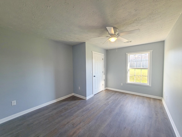 spare room with dark hardwood / wood-style floors, ceiling fan, and a textured ceiling