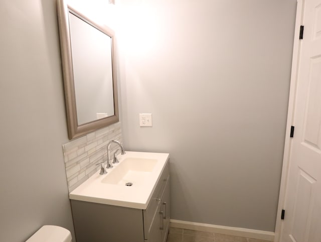 bathroom featuring tile patterned floors, vanity, toilet, and backsplash